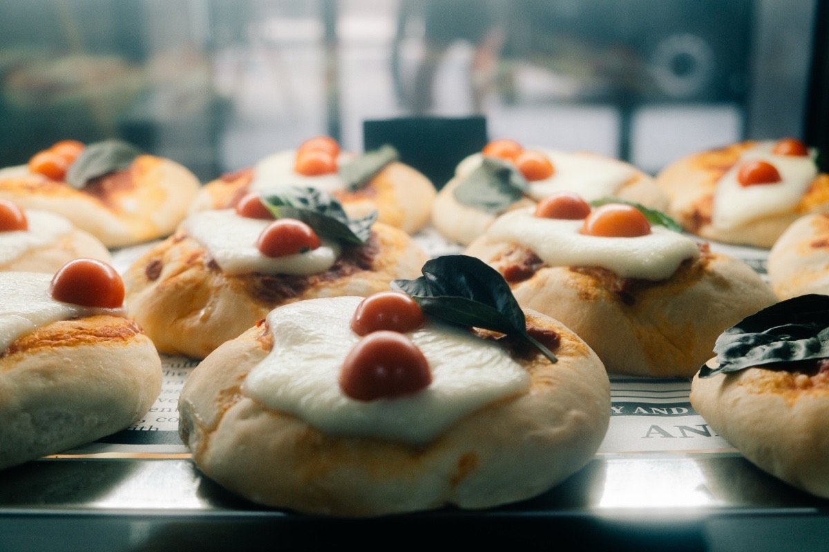 Tray of mini pizzette with mozzarella, cherry tomatoes and fresh basil