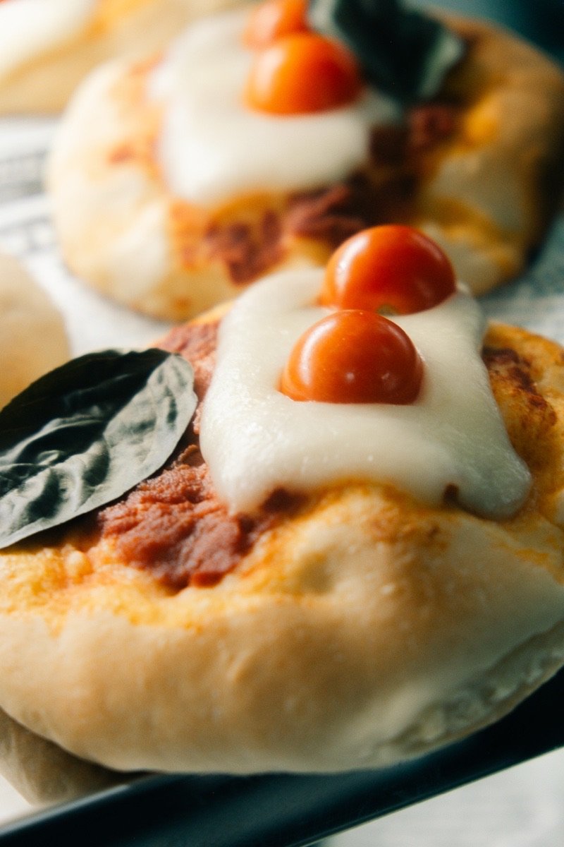 Nduja pizzetta with mozzarella, cherry tomatoes and basil, macro shot