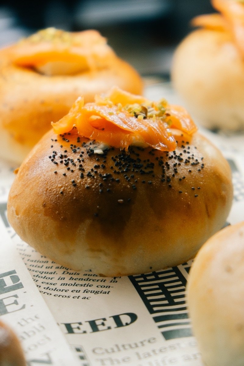 Poppy-seed bun filled with smoked salmon and pistachio cream, close up