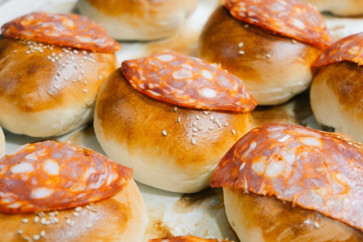 Golden sesame buns topped with spicy Italian salami